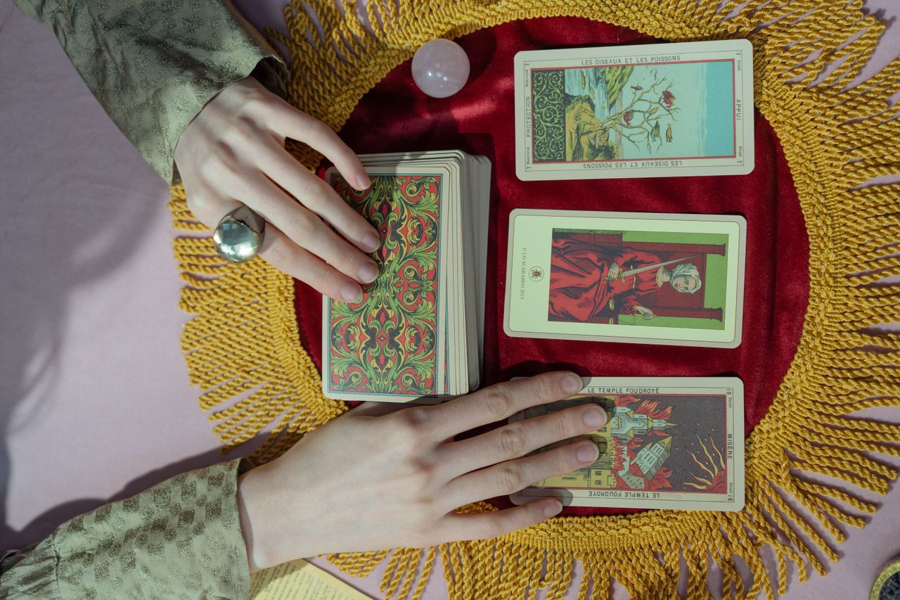 A close-up view of a tarot reading featuring a crystal ball and vibrant tarot cards on a colorful spread.